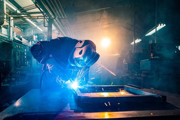 Zwei Handwerker schweißen und schleifen Metall